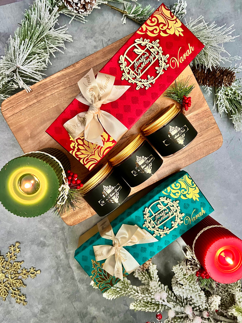 Three Varah snack jars beside red and teal Season’s Greetings gift boxes.