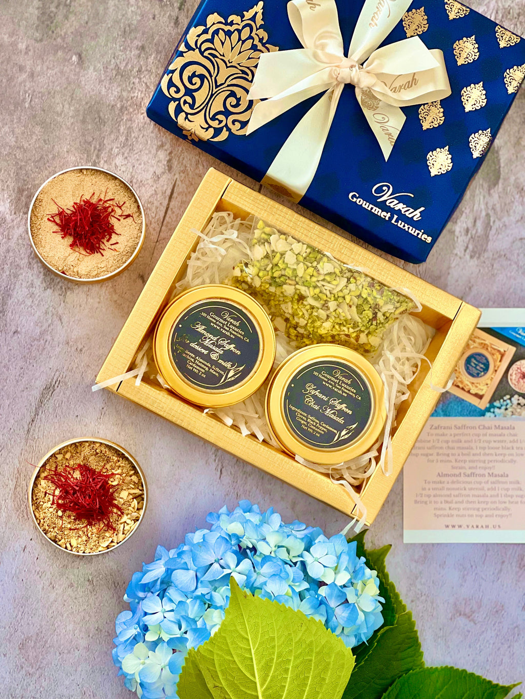 Saffron Masala Chai and Milk Masala in reusable golden tins, in a gold foiled box wrapped with satin ribbon